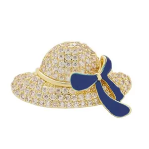 Detailed close-up view of a sparkling hat brooch with navy blue enamel bow design.