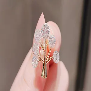 Detailed macro view of an elegant gold tree-shaped brooch with sparkling stones