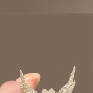 Close-up of a winged heart brooch with sparkling stones for clothes fixing