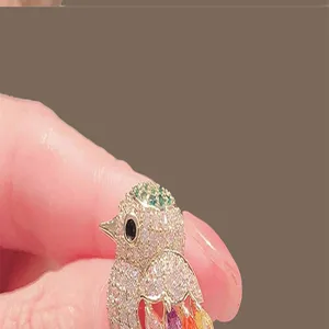 Detailed macro view of a sparkling bird brooch featuring colorful pave-set crystals