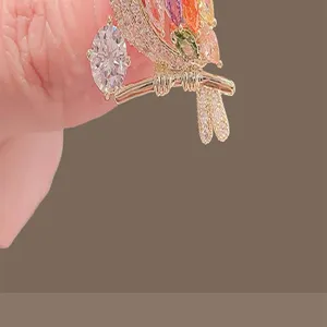 Detailed macro view of high-end bird brooch featuring vibrant multi-color rhinestones