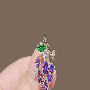 Detailed macro view of an elegant grape-shaped brooch featuring purple and pink rhinestones
