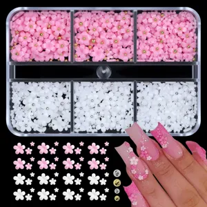 Close-up of mixed 5-petal resin flower nail charms in a clear 6-grid organizer box.