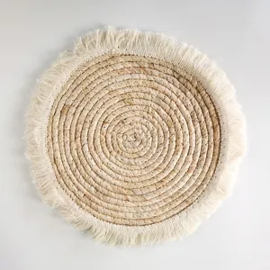 Close-up detail of natural woven straw placemat with elegant white fringe edge for home decor.