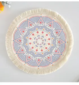 Detailed view of bohemian round woven cotton placemat with mandala print and tassel fringe.