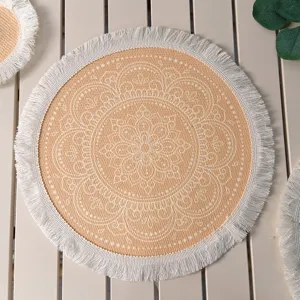 Macro view of Bohemian round woven placemat with white mandala pattern and fringe
