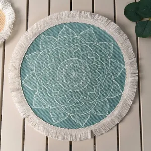 Detail view of teal bohemian round placemat with white mandala print and fringe trim