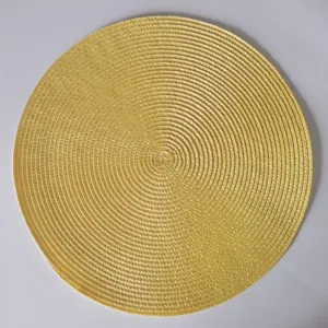 Dettaglio tovaglietta rotonda intrecciata in PP dorato con trama a spirale isolante termica.
