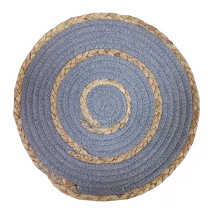 Round woven placemat with natural grass and grey cotton rope for dining table heat insulation.