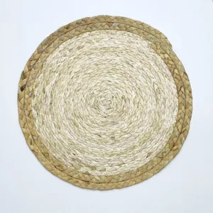 Detailed shot of natural woven straw placemat, handmade round table mat for kitchen and decor.