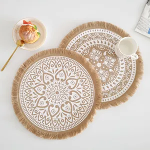 Detailansicht eines runden Platzsets aus Jute mit weißem Mandala-Muster und Fransenrand