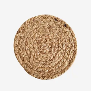 Primer plano de un mantel individual circular de paja natural tejida a mano