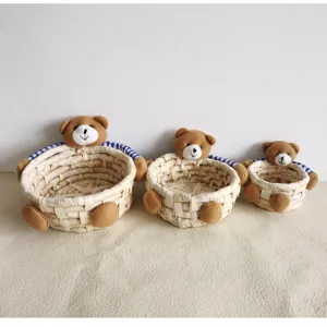 Cute corn husk woven storage basket set with adorable teddy bear decor, perfect for home.