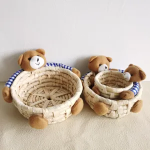 Cute woven corn husk storage basket set featuring plush teddy bear hugging arms for home decor.