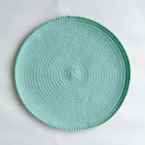 Round braided placemat with pom pom edge, mint green table mat for kitchen and dining decor.