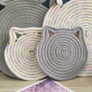 Close-up detail of cat-ear shaped cotton rope mats in grey and rainbow stitched white colors