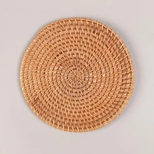 Detalle de posavasos redondo de ratán tejido a mano, alfombrilla térmica natural.