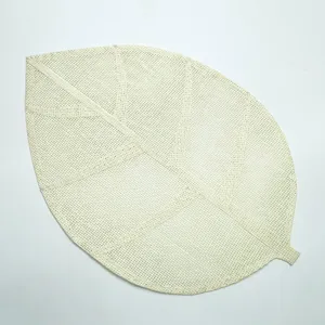 Woven leaf shaped placemat detail, natural paper table mat for dining room and kitchen decor.