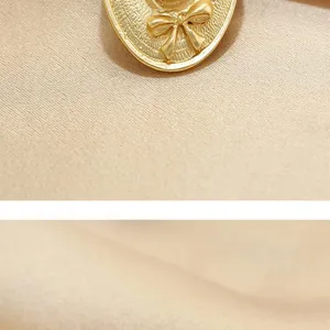 Close-up detail of vintage golden hat brooch with bow, perfect for elegant suit decoration.