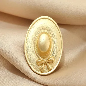 Vintage gold hat brooch detail, elegant metal bow pin accessory for women suits and coats.