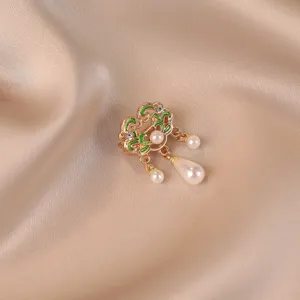 Close-up of a vintage Chinese style Ruyi lock brooch with pearls and green enamel details