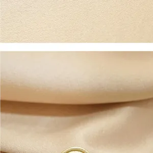 Close-up detail of smooth fabric texture and metallic brooch edge for elegant women suits.