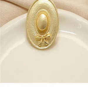 Close-up detail of the vintage hat metal brooch, showing elegant texture and bow decor.