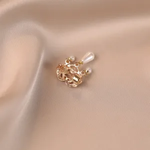 Close-up of vintage gold pearl brooch with auspicious cloud and peace lock design