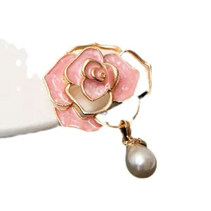 Elegant pink camellia flower brooch with hanging pearl, exquisite gold-rimmed coat accessory.