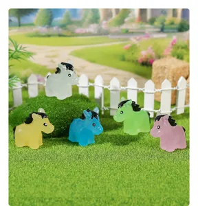 Close-up of colorful luminous mini horse figurines in a miniature garden setting