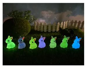 Vista dettagliata di piccole figurine di conigli in resina luminosa per micro paesaggi.