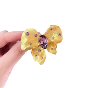 Elegant gold butterfly brooch with purple crystal and sparkling rhinestone decor for fashion women.
