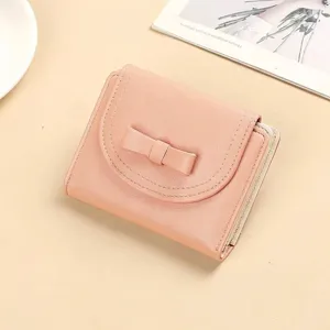 Elegant pink women's short wallet with decorative bow and secure zipper closure design