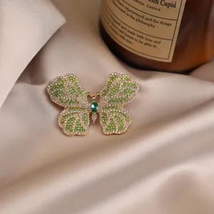 Exquisite alloy butterfly brooch with sparkling green and clear crystals. Elegant accessory.