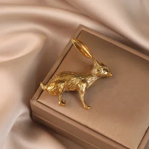 Gros plan sur les détails de la broche lapin dorée, texture fine et éclat métallique élégant.