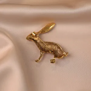Gros plan détaillé de la broche lapin vintage dorée avec un travail en métal texturé.