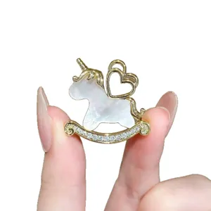 Exquisite mother of pearl unicorn rocking horse brooch, elegant crystal embellished fashion.