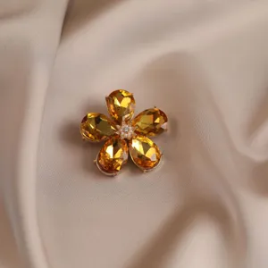 Exquisite vintage crystal flower brooch detail view, premium amber petals with pearl center.