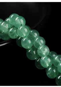 Detailed macro view of high-quality natural green strawberry quartz beads for DIY jewelry