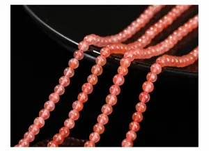 Gros plan détaillé de perles rondes en agate rouge cerise naturelle pour bijoux