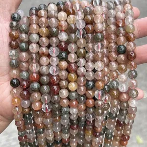 Macro detail of 3A natural red and green rutilated quartz beads for DIY jewelry making.