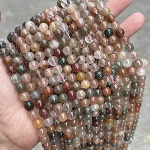 Close-up detail of natural red and green rutilated quartz loose beads with clear inclusions