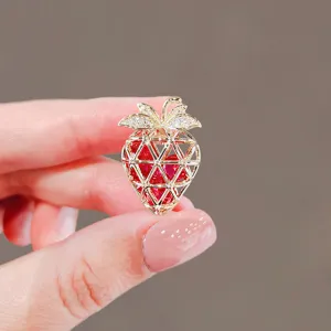 Gold strawberry brooch with red crystals and cute design, perfect suit accessory for women.