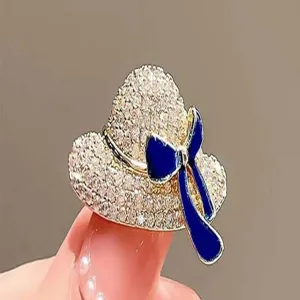 Exquisite rhinestone hat brooch detail, sparkling crystal and deep blue bow accessory close-up