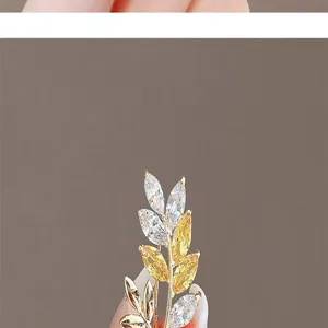 Elegant leaf-shaped brooch with white and yellow marquise-cut zircons in gold setting.