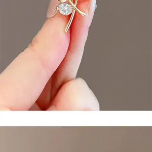 Detailed macro view of an elegant gold brooch pin featuring sparkling clear leaf crystals