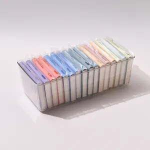 Detail shot of colorful mini pocket notebooks neatly arranged in a clear plastic storage box.