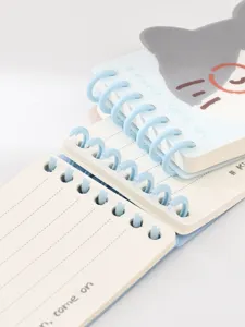 Detalle de cuaderno de espiral de bolsillo de dibujos animados, papelería rayada.