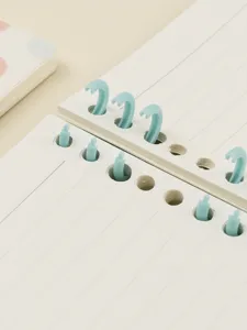 Close-up detail of cute loose-leaf notebook binder rings and clean lined paper for daily journaling.