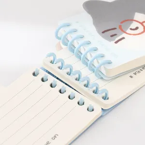 Lindo cuaderno de bolsillo con espiral azul claro y páginas rayadas para estudiantes.